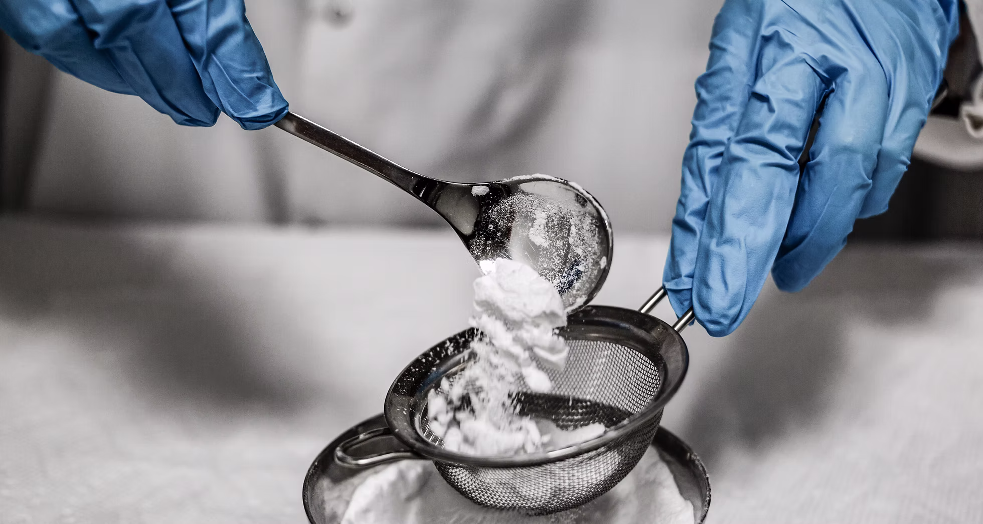 Quality control — gloved hands sieving a tapioca starch sample